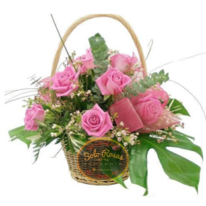 Canasta de 10 rosas rosadas en base de mimbre con flores de complemento de Solo Rosas
